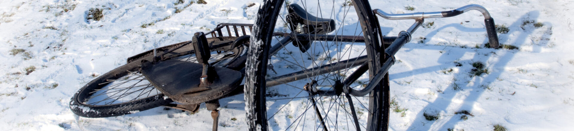 Een fiets die ligt in de sneeuw.