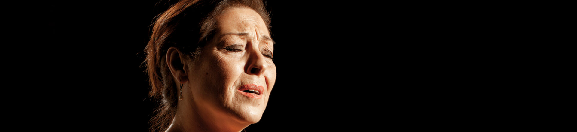 Maria de Fatima zingt met haar ogen dicht en haar handen omhoog.